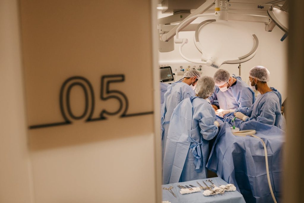 A group of surgeons operates in a hospitals sterile environment, focusing on a complex procedure.